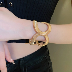 Detailed view of golden snake-style coil bracelet with brushed metallic texture and spiral wrap