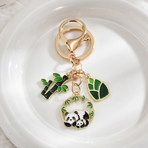 Detailed view of panda and bamboo metal keychain with green enamel leaves and charms