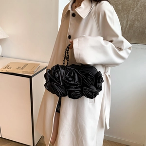 Detail of black satin 3D rose evening bag with elegant beaded handle and floral layers