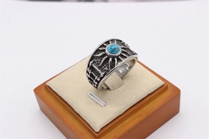 Macro d'une bague vintage argentée avec pierre turquoise et gravures de soleil