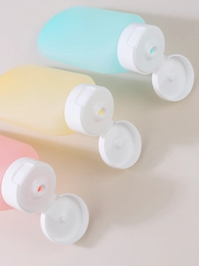 Three travel silicone squeeze bottles in pastel mint green, cream yellow, and cherry pink
