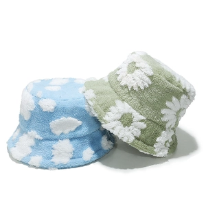 Detail of plush bucket hats with light blue cloud and green daisy patterns on teddy fleece