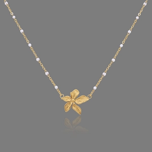 Detailed view of the 18K gold plated flower pendant with white beads and metal texture