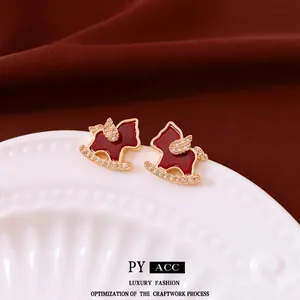 18K gold plated rocking horse earrings with red enamel and crystals on white porcelain