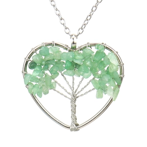 Detail of handmade wire wrapped heart pendant with green crystal gravel tree of life