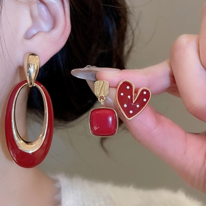 Close-up of vintage red jewelry set including oval drops and heart studs on model