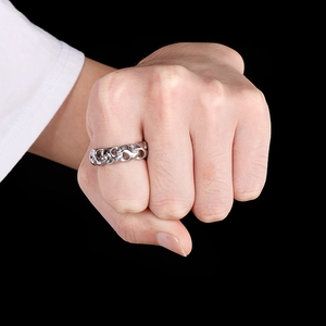 Close-up of a men's silver stainless steel curb chain ring worn on a hand