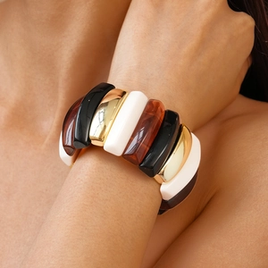 Detail shot of wide bohemian resin bracelet with marble and gold patterns on a wrist