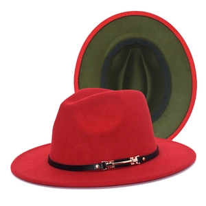 Detail of red and olive green two-tone fedora hat with black leather strap and gold buckle