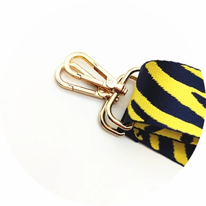 Close-up of yellow and blue tiger print bag strap with golden swivel hook detail