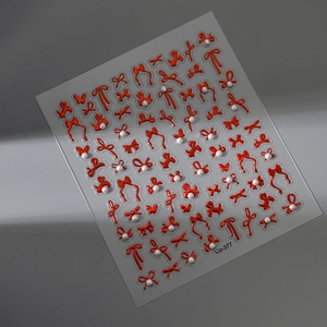 Macro detail of red bow nail stickers with 3D embossed texture and pearl accents