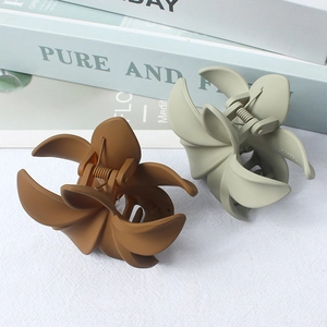 Matte flower hair claws in caramel brown and sage green with 45-degree view