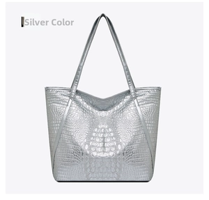Close-up of silver crocodile embossed tote bag with glossy faux leather texture
