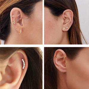Close-up of gold S925 silver ear studs featuring moon, star, and butterfly designs