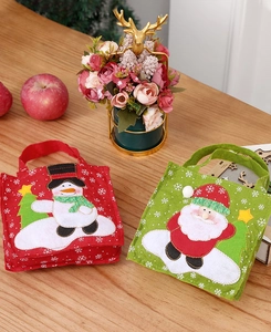 Detail of Christmas felt gift bags with embroidered snowman and Santa Claus designs