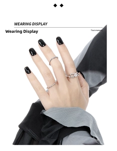 Detailed view of three-piece silver ring set with hollow diamond inlay on hand