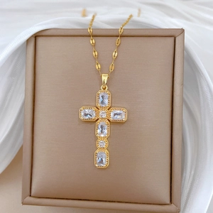 Vue macro d'un collier croix doré avec des pierres de zircone cubique variées