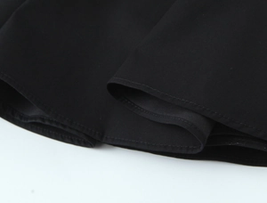 Close-up of double stitching and fabric texture on a sleeveless black mini dress