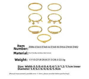 Detail view of 18K gold plated stainless steel bangles featuring bear and heart charms