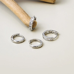 Silver geometric pleated hoop earrings with sparkling cubic zirconia in a minimalist style