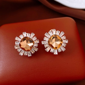 Detailed close-up of champagne zircon sunflower earrings on a red luxury jewelry box
