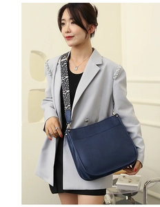 Detail of dark blue crossbody tote bag featuring a wide leopard print shoulder strap