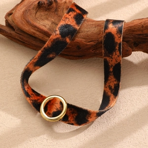 Dettaglio ravvicinato della collana choker in velluto leopardato con anello in metallo oro