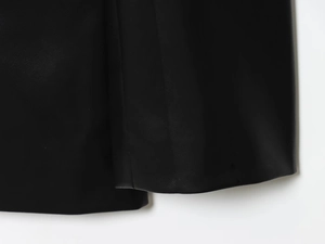 Detailed macro view of the black faux leather hemline and professional stitching finish