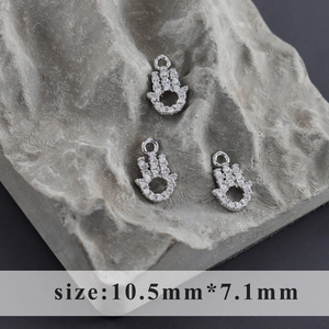 Macro shot of silver Hamsa Hand pendants with zircon pavé measuring 10.5mm by 7.1mm