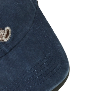 Detailaufnahme der dunkelblauen Baumwoll-Basecap mit Steppnähten und Bären-Stickerei