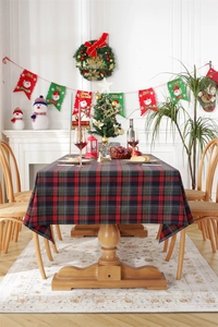 Detailed view of red and green plaid Christmas tablecloth in a festive dinner setting
