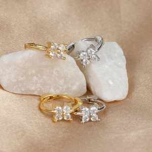 Détail de boucles d'oreilles trèfle en zircon, finitions or et argent sur soie et pierre