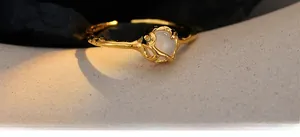 Macro detail of gold open ring with natural lava texture and white agate gemstone