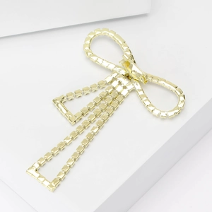 Elegant gold bow brooch with sparkling square rhinestones and fringe on white background