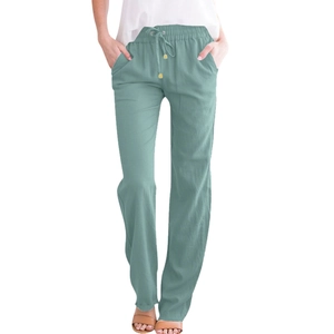 Detail of mint green linen trousers featuring an elastic waistband and adjustable drawstring