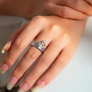 Detail shot of a silver crown-shaped stainless steel ring worn on a finger