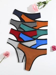 Flat lay of colorful ribbed cotton thongs for women with contrast trim and floral decor
