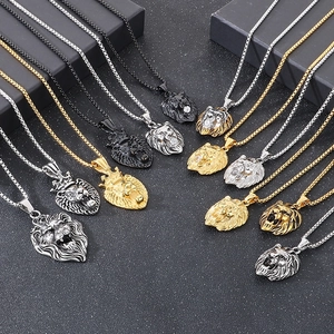 Gros plan de pendentifs tête de lion en or, argent et noir avec accents de zircon