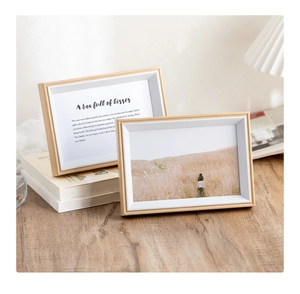 Detail of light oak wood photo frames with white matting on a wooden desk setup