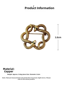 Macro detail of intertwined vintage gold snake brooch featuring green gemstone eyes