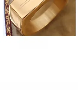 Close-up of highly polished 18k gold plated wide band ring with minimalist design