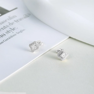 Close-up of S925 silver rhombus stud earrings with square zircon and beaded edge detailing