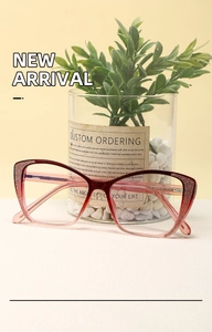 Close-up of cat-eye glasses with red to transparent pink gradient and glitter details