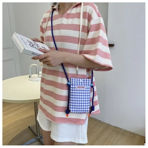 Detailed view of a blue checkered mini crossbody bag with a blue knotted shoulder strap