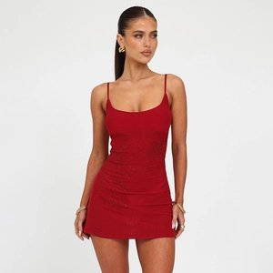 Detailed close-up of red rhinestone spaghetti strap dress with textured sequin embroidery