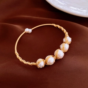 Detail of handcrafted gold-plated wire wrapped bracelet with six freshwater pearls
