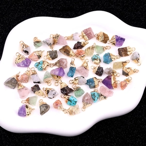 Raw natural crystal pendants with gold plated edges on a white cloud tray
