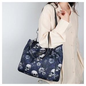 Detail view of navy blue oxford tote bag featuring skull and floral pattern print