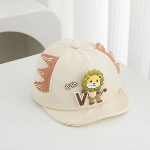 Detail of baby baseball cap with 3D lion design and small dinosaur fin decorations