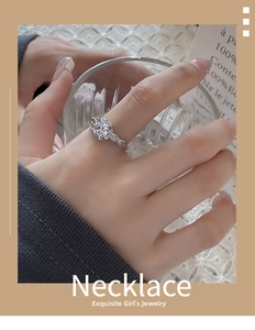 Detailed view of silver zircon ring with twisted band worn on model hand in home setting